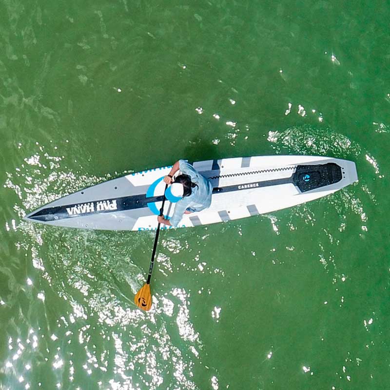 an aerial image of a woman paddling the cadence paddleboard
