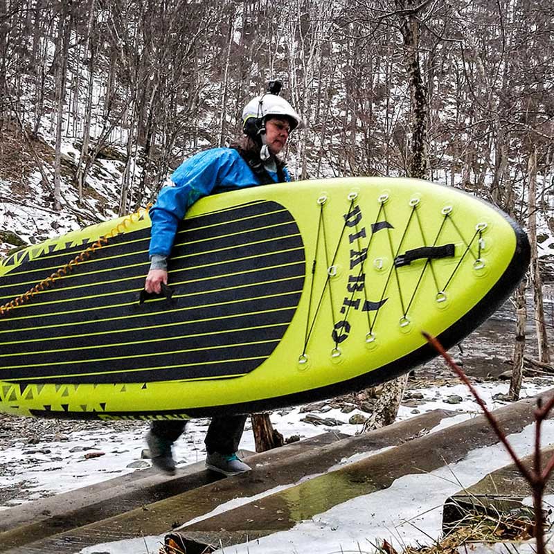A woman holding the diablo air inflatable paddleboard