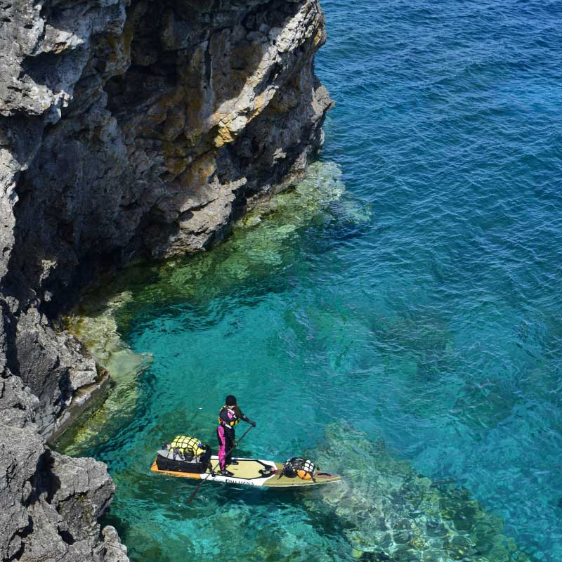 a woman exploring coves in the sea on the endurance paddleboard
