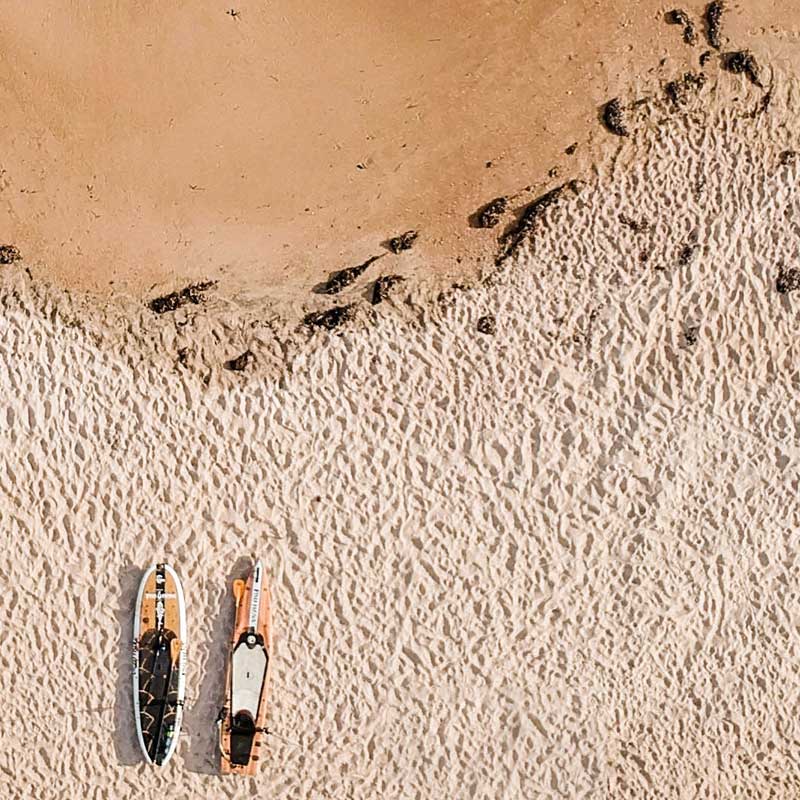 two paddleboards on a beach 