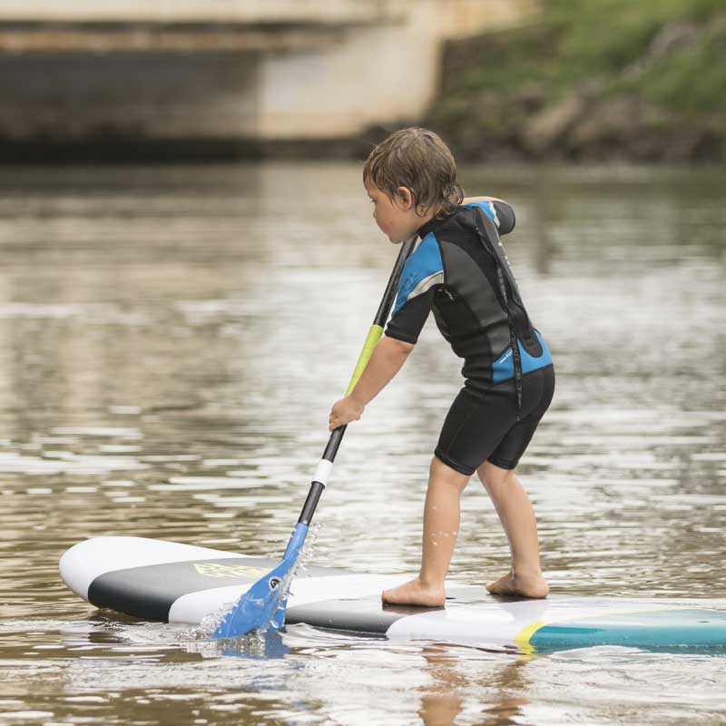 A child paddling a kids paddleboard on a river
