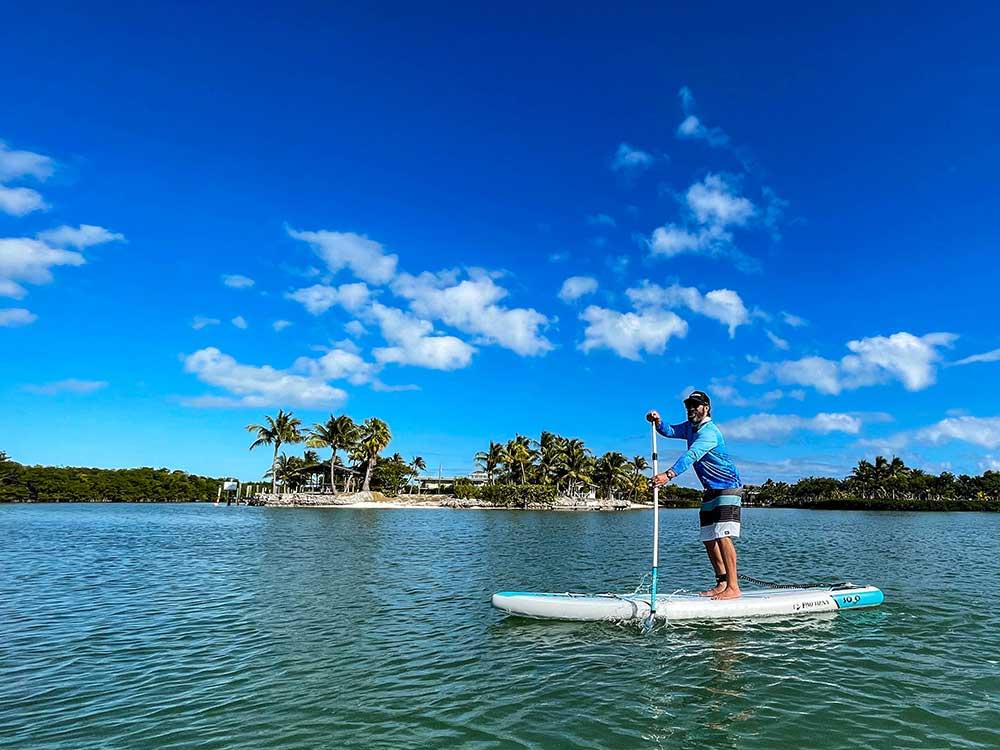 A man is paddling an inflatable stand-up paddle board