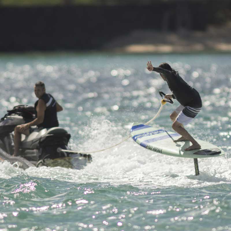 A person hydrofoiling on the carve pro paddleboard behind a jetski