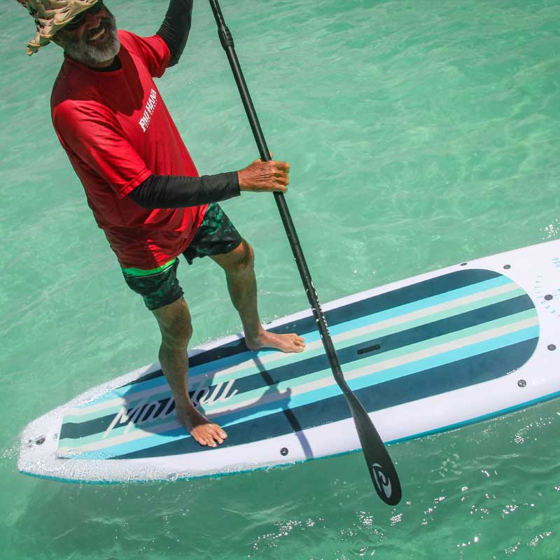 a man having fun on a stand up paddleboard on the ocean