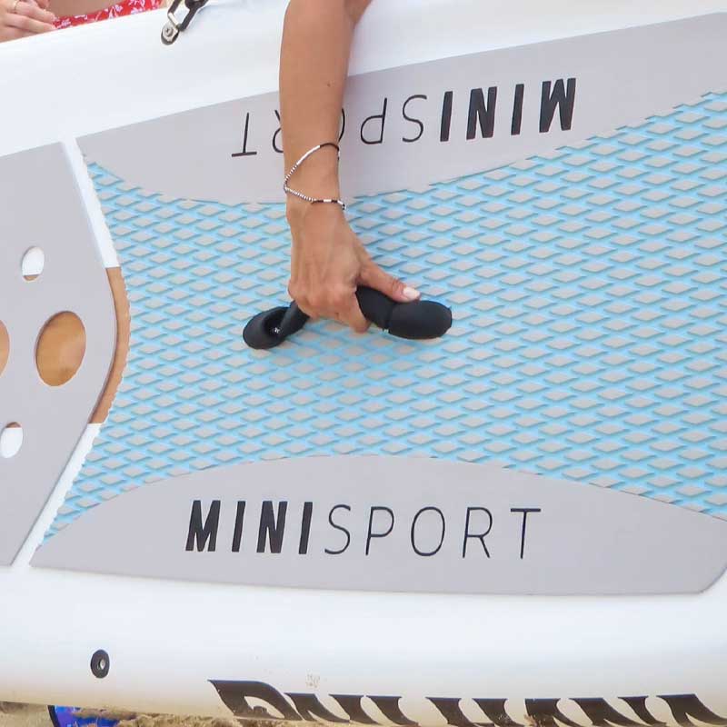 A person holding the Minisport paddleboard using the neoprene handle