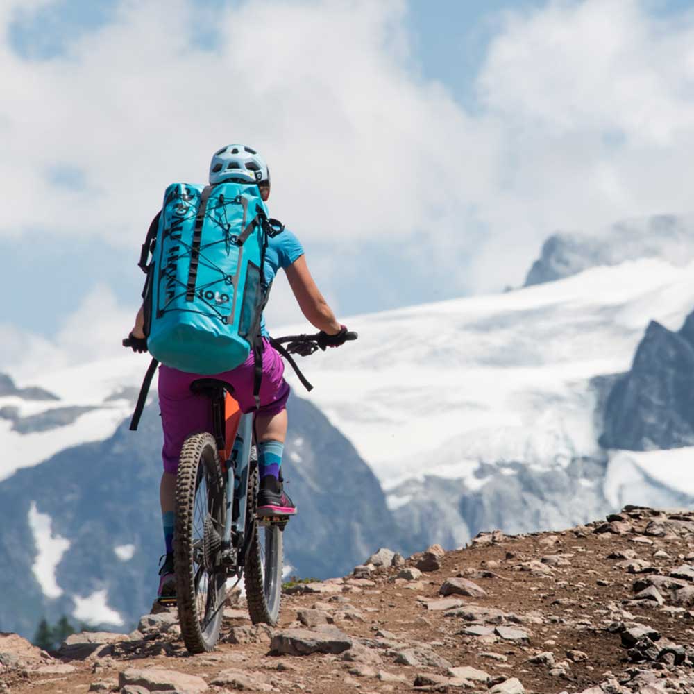 cycling through the mountains wearing the solo sup backcountry drybag backpack