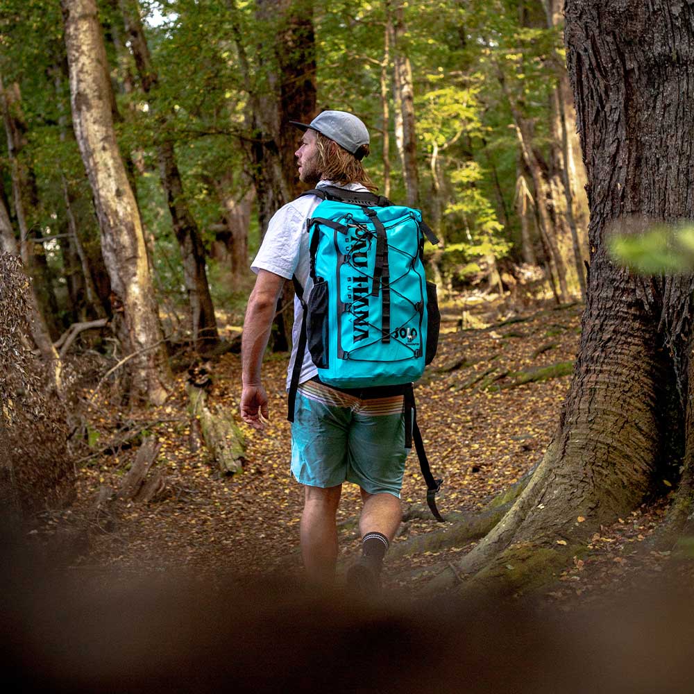 Hiking through the forest with the solo sup backcountry paddleboard in a backpack