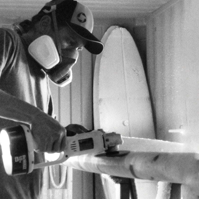 Shaping a paddleboard in a warehouse